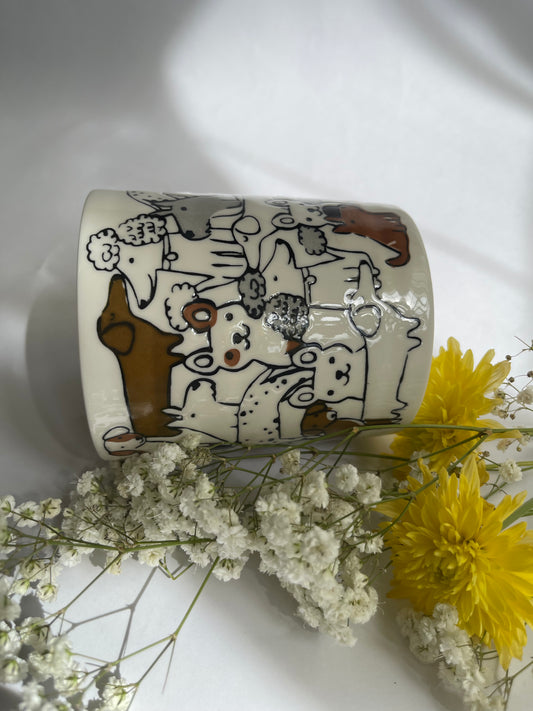 Ceramic mug with cartoon designs on a white surface with flowers