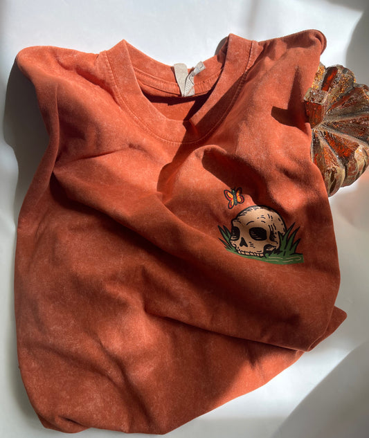 Orange shirt with skull design on a white background