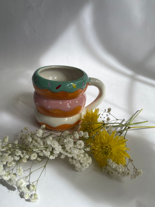 Colorful striped mug with flowers on a white surface
