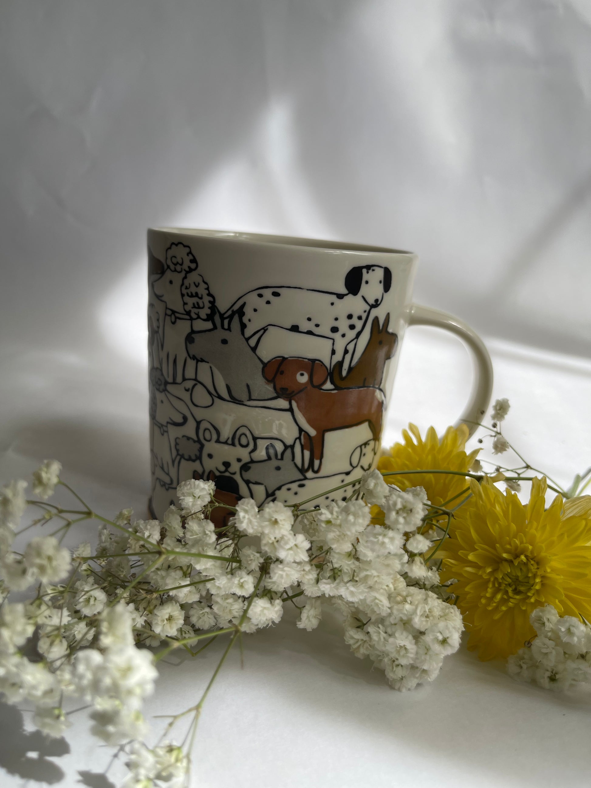 Mug with dog design surrounded by flowers on a white background
